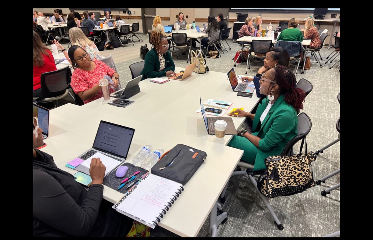 Dr. Natalie Edwards-Hudson working alongside colleagues at a conference roundtable