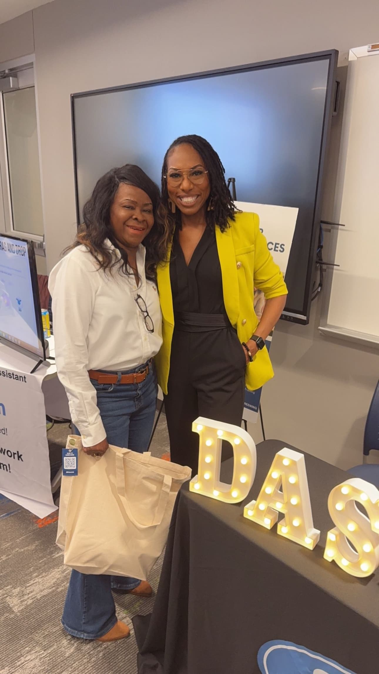 Dr. Natalie Edwards-Hudson posing with a colleague at a conference exhibit booth