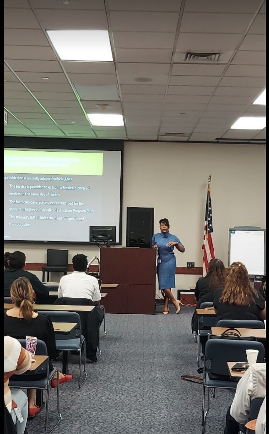 Dr. Natalie Edwards-Hudson presenting on special transportation and IEP requirements at a podium